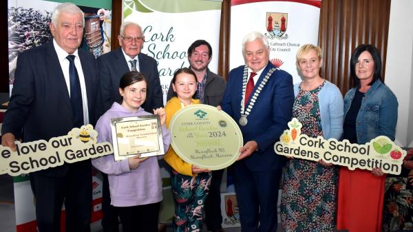 Mayor of the County of Cork, Cllr. Frank O'Flyn along with three other men and two women presenting an award to the winners of the Schools Garden competition.