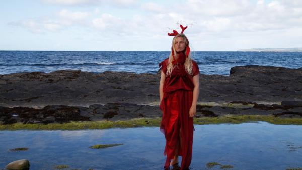 A woman in a red dresss standing in water