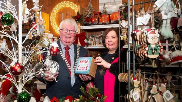 The Mayor of the County of Cork, Cllr Joe Carroll and Chief Executive of Cork County Council, Moira Murrell, visiting 'Designs' craft and gift shop and holding a 'Shop Local' sign.