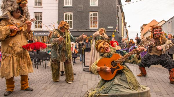 A group of entertainers in costume playing instruments.