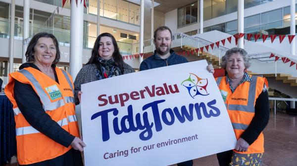 Members of Tidy Towns holding a Tidy Towns banner.