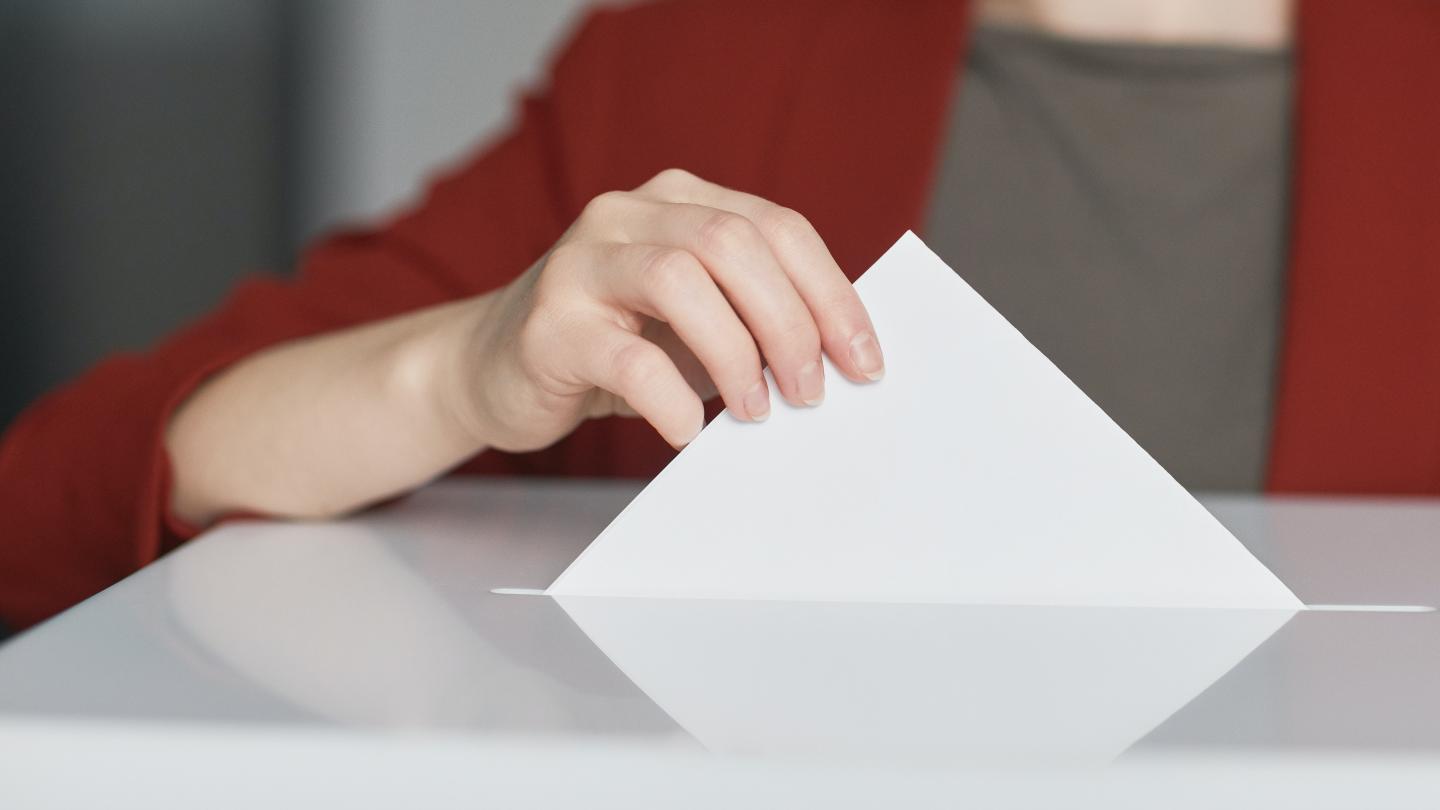 Person putting a ballot in to a ballot box