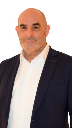 Man in a navy blue suit jacket with a white shirt against a white background.