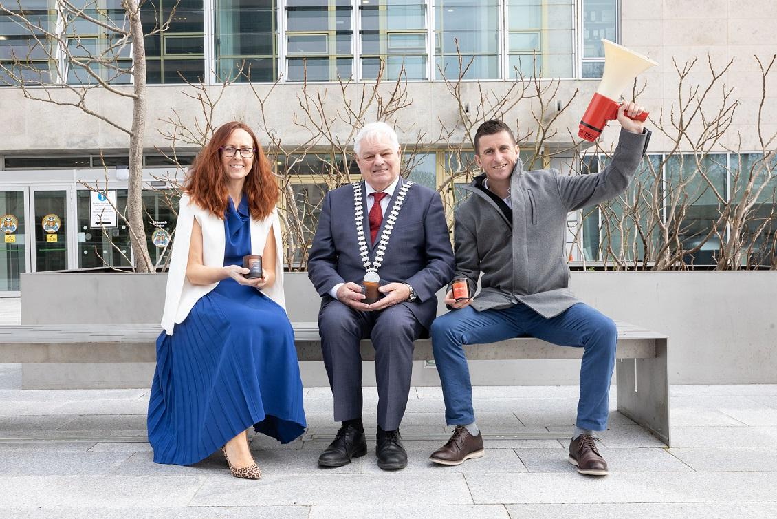 The Mayor of the County of Cork, Cllr. Frank O'Flynn sitting next to a man and a woman on a bench