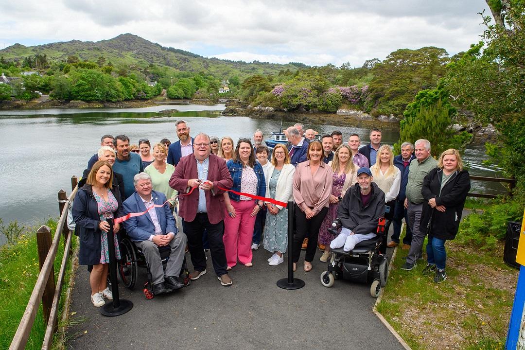 Cllr. Danny Collins accompanied by approximately 25 people as he cuts the ribbon at Blue Pool Trails, Glengarriff.
