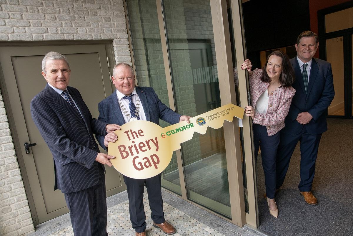 Three men and one woman pictured with 2 of the men holding an oversized cardboard key on which is written Briery Gap, Cumnor Construction and Cork County Council.