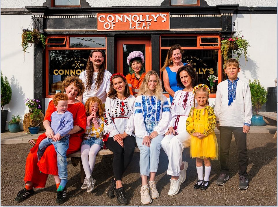 A group of people sitting outside of Connolly's of Leap.