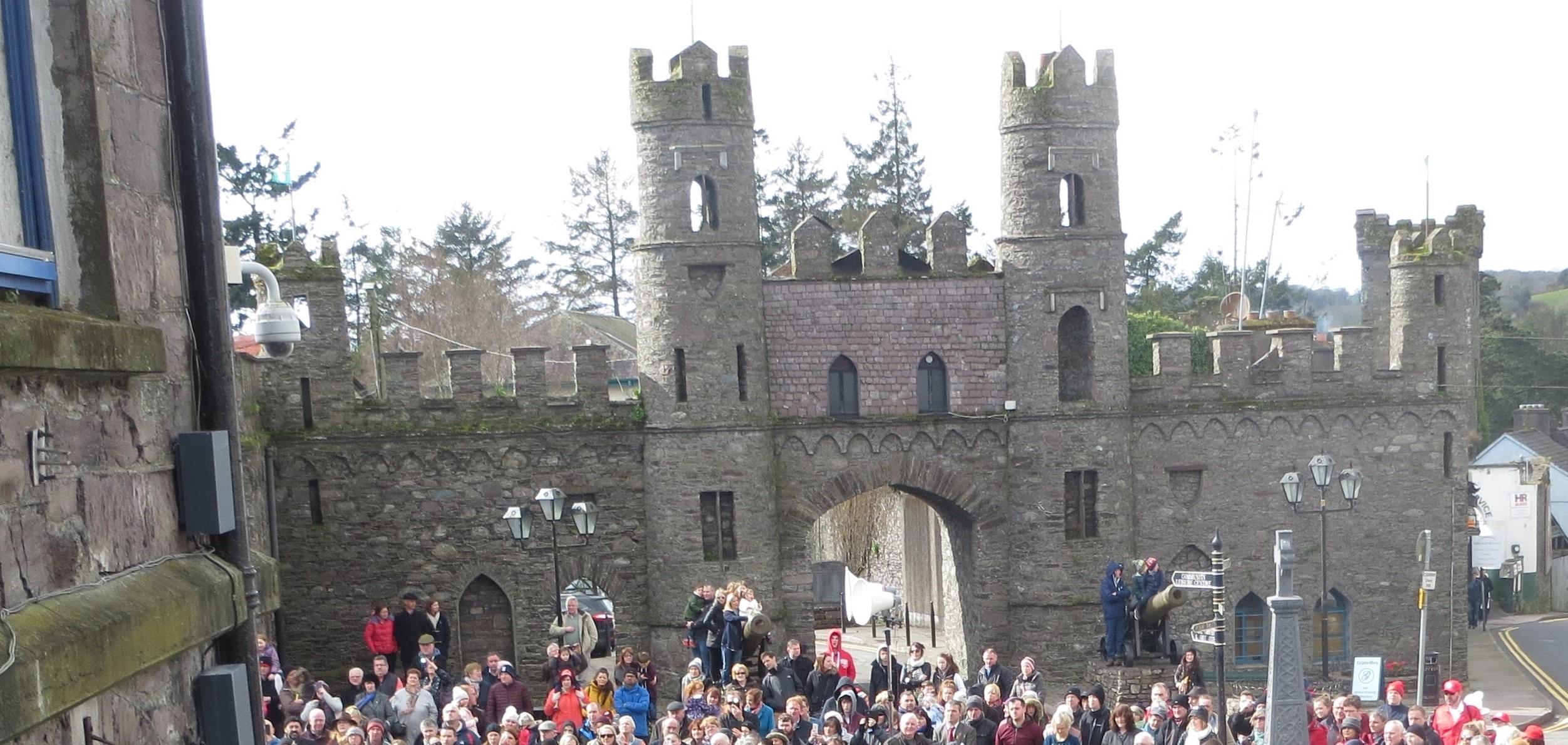 A castle with many people stadning outside