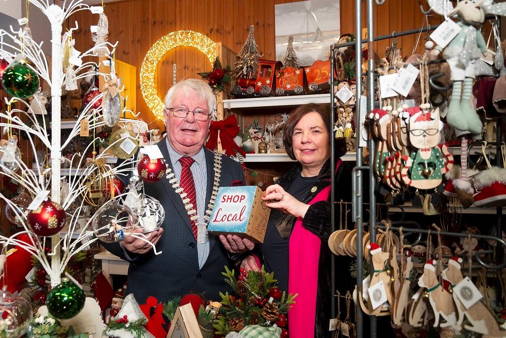 The Mayor of the County of Cork, Cllr Joe Carroll and Chief Executive of Cork County Council, Moira Murrell, visiting 'Designs' craft and gift shop and holding a 'Shop Local' sign.