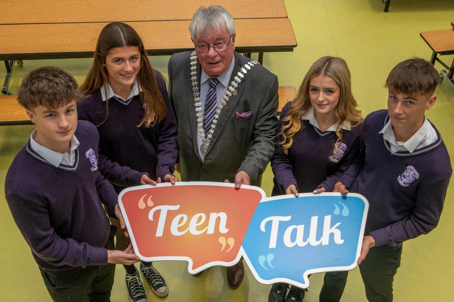 A group of people holding a teen talks sign