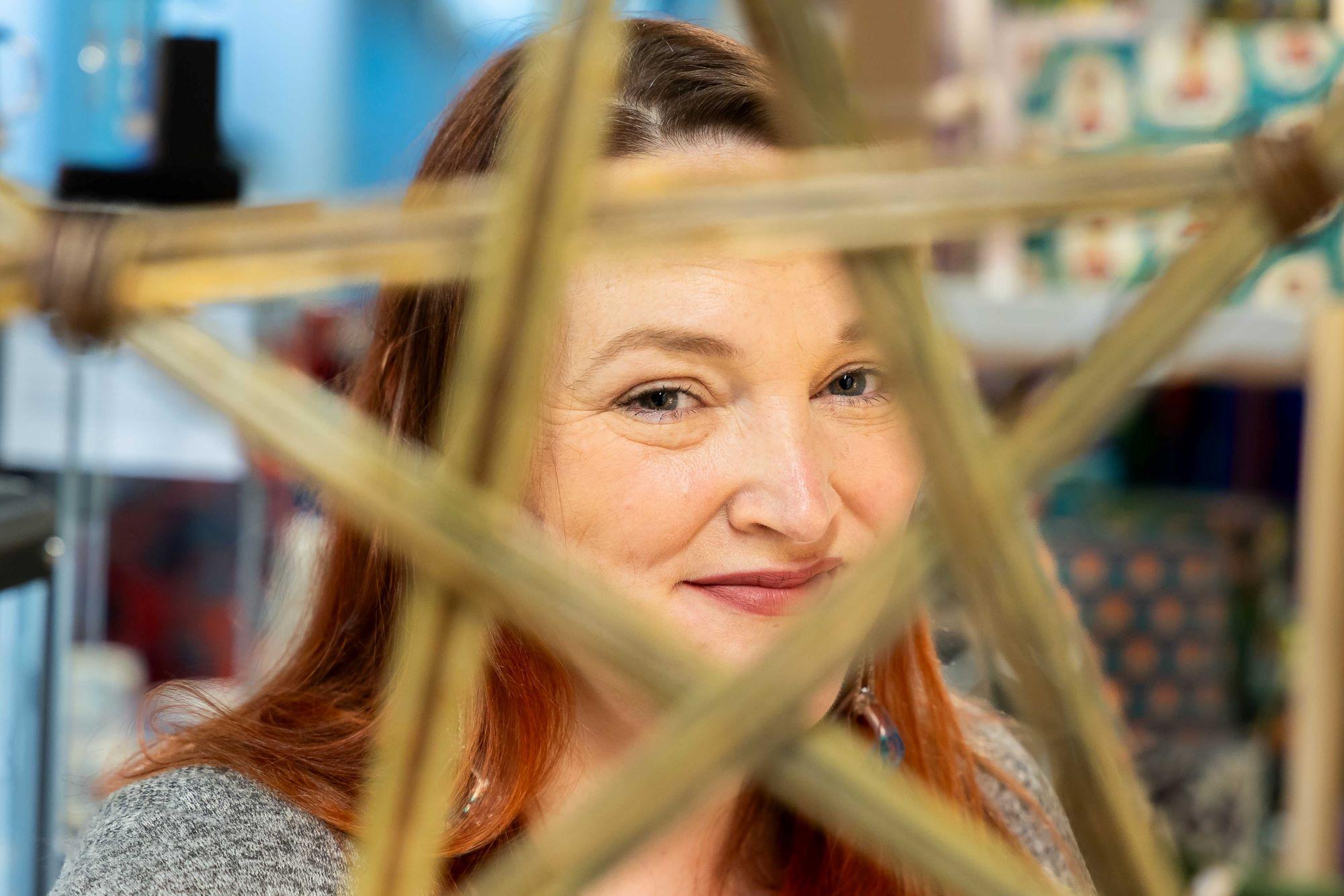 A woman looking through a star shaped piece of art